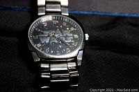 Star Wars watch front face showing large Star Wars logo and multicolor sparkles on black dial with metal bracelet.