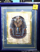 Full view of King Tut artwork framed in deep royal blue frame with double green and gold matting, showing the complete artwork on cloth.