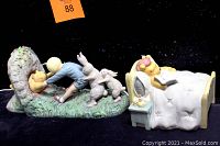 Front and side view of two Winnie the Pooh themed bookends featuring Pooh, a boy, and two rabbits, and a night light shaped as Pooh in bed.