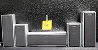 Front view of five Sony speakers: one center, two front, and two surround speakers, with the Sony logo on each and a black grille covering the drivers.