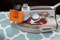 Side view of Rowenta Steamium DW9080 steam iron showing control dial, steam button, and water tank.