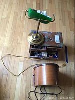 Desk lamp with missing lampshade part, Thomas model 217 radio, and wooden jewelry box on floor