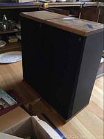 Two Acoustic Research floor-standing speakers side by side, showing wooden tops and black fabric front