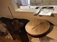 Violin and drum on table with fifes and book on counter