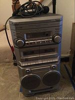 Full front view of The Singing Machine SMG299 karaoke machine showing speakers, cassette deck, CD player, and control knobs.