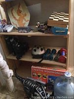 Shelf with assorted toys, weights, chess board, wood shield and sword