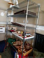 Full view of five-tier chrome wire shelving unit loaded with miscellaneous items.