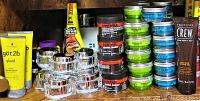 Shelf view of chrome and black styling jars with tubes behind