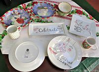 Lot composition arranged on holiday tablecloth showing all dinner plates, serving platters, mugs, and bowls