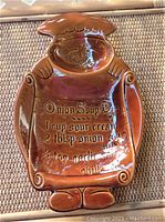 Brown glazed ceramic onion soup dip serving dish shaped as a chief figure with embossed recipe.