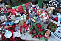 Wide view of various Christmas holiday decorations including stuffed figures, ornaments, holiday pillows, gift boxes, and lights.
