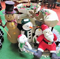 Full lot view showing wood snowman, fabric snowman, dog figure, plush Santa, reindeer figure, and wreaths