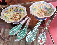 Top front view showing 2 hexagonal bowls and 4 decorative Chinese soup spoons on glass table