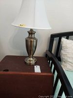 24-inch metal table lamp showing urn-shaped brushed metal base with white fabric shade
