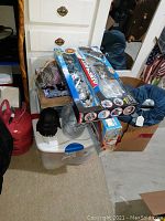 Photo shows the aircraft carrier set box with planes on top and other items including Darth Vader head and a metal bucket around it.