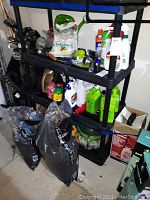 Full view of shelf with assorted garden supplies including bags, bottles, and tools.