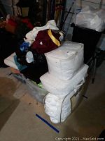 Overall view of the lot showing multiple linens stacked including comforters and towels