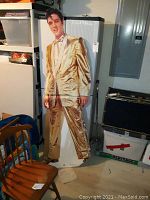 Full view of the 6-foot Elvis Presley cardboard cutout in a gold suit, showing some creasing and folds.