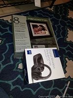 Boxed Pandigital 8 Inch LCD Digital Photo Frame with specifications and an Insignia Digital Wireless Headphones box