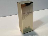 Gold shiny box of cle de peau Beaute cleansing cream, front view showing brand and size 9ml 0.29oz