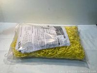 New, factory-sealed bag containing yellow plastic link warning chain with Brady label and product sheet inside package.