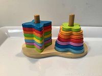 Photo showing the wooden stacking toy with star and flower-shaped colorful pieces on wooden base