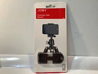 Front view of the product packaging with the Joby GripTight ONE Mount inside, showing the mount and ball head on a tripod attachment.