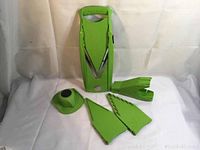 Full set including Borner V Power mandolin slicer, two bladed inserts, plain insert, safety clip, and storage caddy laid out on white background.