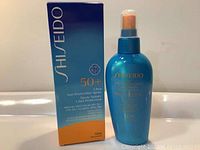 Blue Shiseido Ultra Sun Protection Spray SPF50+ 150ml bottle next to original box with product branding and text.