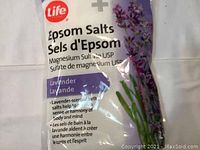 Photo of a white sealed bag of Epson Salts with lavender scent and image of lavender flowers, showing product branding and description in English and French.
