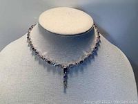 Front view of the Givenchy choker necklace featuring iridescent crystal beads and a drop crystal pendant on a white display bust.