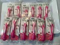 Photo showing all 12 Schick Quattro razors in original sealed packaging arranged side by side.