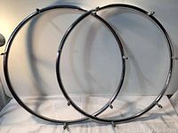 Two chrome circular racks leaning against a wall, showing overall shape and condition