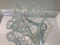 Top angle view of unique woven glass bowl showing the intricate weave pattern and iridescent finish