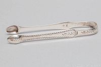 Full view of sterling silver sugar cube tongs showing elegant engraved patterns and rounded gripping tips.