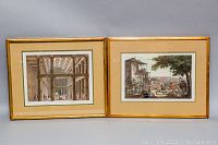 Two framed etching prints side by side showing architectural and street scenes with gold-tone frames and matting.