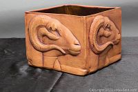 Side view showing the raised ram head design in terracotta on the planter pot.