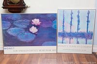 Two framed Monet posters side by side on the floor against a wall, showing their size and condition.