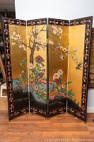 Front side full view showing gold lacquer background with floral and bird design and black border with pink geometric motifs