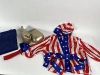 Gold TITLE boxing gloves, American flag robe, and red, white, and blue hand towels displayed on white background