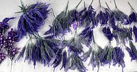 Artificial lavender sprigs arranged horizontally, showing light purple flowers and green stems.