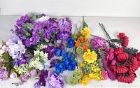 Full assortment of artificial flowers laid out showing various colors and flower types.