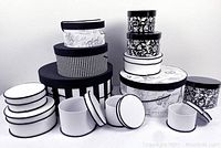 Full collection of 15 decorative black and white hat boxes showing various sizes and patterns.