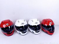 Four full face helmets: two red (large and extra large), two white (large and extra large) shown in single row.