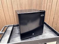 Front view of black Whynter upright mini freezer with lock on door.