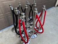 Cluster of chrome stanchion posts with attached red and black velvet ropes.