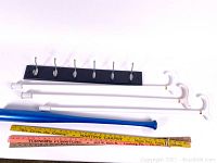 Photo showing entire lot including 3 white canes with curved handles, blue painted baseball bat, and three vintage yardsticks with advertising.