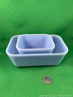 View of two nested rectangular Pyrex Delphite Blue fridge containers with Canadian quarter for scale, against a green background.