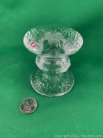 Clear glass single-ring Festivo candlestick photographed with a Canadian quarter coin for scale, showing texture and Iittala sticker.