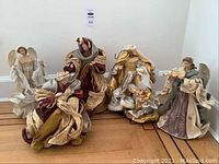 Photo showing the full set of six Christmas figurines including angels, Mary, and Joseph with varied colors and textures.